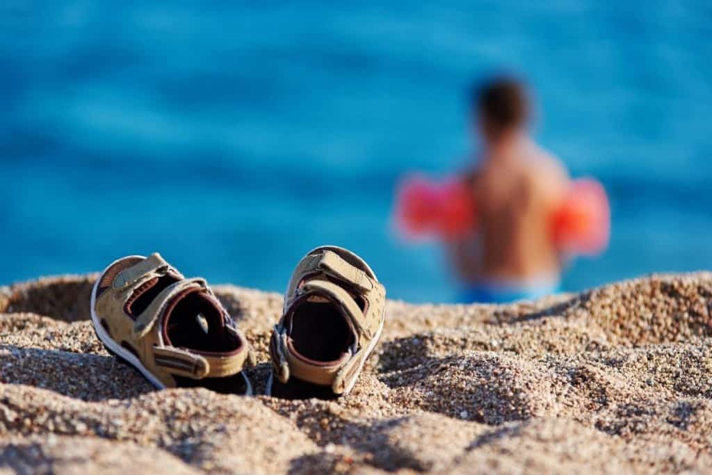 Lasten sandaalit rannalla